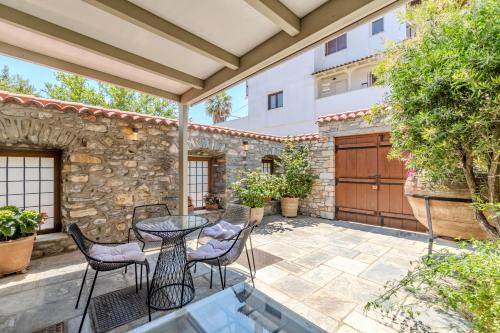 a patio with a table and chairs and a building at Chroma Pelion Villas in Kato Gatzea
