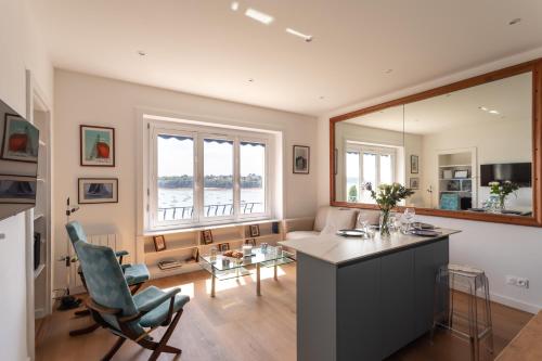 une cuisine et un salon avec une table et des chaises dans l'établissement Le Beauvoir 1 - Appt vue mer, à Dinard