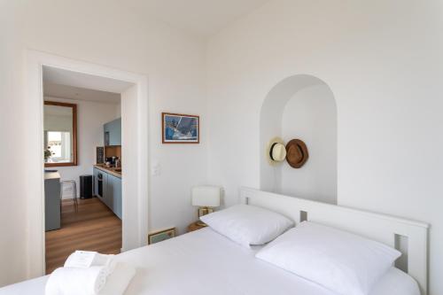 Cet appartement comprend une chambre avec 2 lits blancs et une cuisine. dans l'établissement Le Beauvoir 1 - Appt vue mer, à Dinard