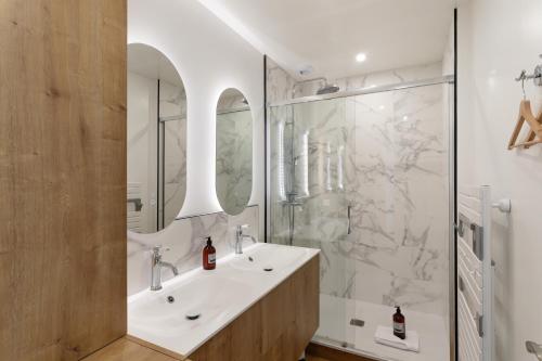 une salle de bain avec deux lavabos et une douche dans l'établissement Le Beauvoir 1 - Appt vue mer, à Dinard