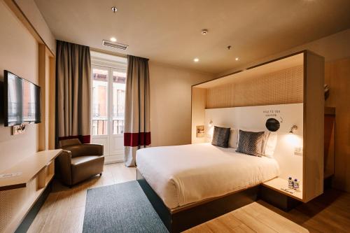 a hotel room with a bed and a chair at Toc Hostel Madrid in Madrid