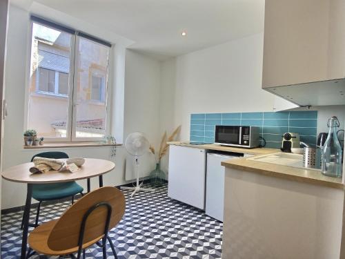 une cuisine avec une petite table et des chaises dans l'établissement Le Saint-Georges, BNBConciergerie, à Lyon