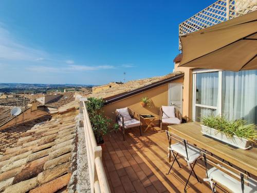a patio with a wooden table and chairs on a roof at Hotel Lauri in Macerata