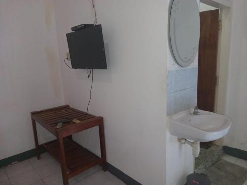 a bathroom with a sink and a mirror at Hotel Wisata in Labuan Bajo