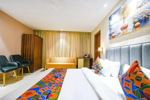 ルディヤーナーにあるFabHotel Supreme Suitesのベッドと椅子のあるホテルの部屋
