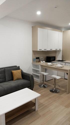a living room with a couch and a kitchen at Hide Apart Hotel in Aktau