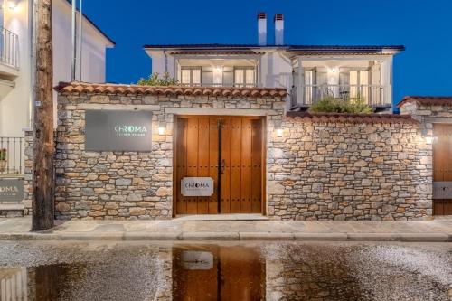 a stone building with a wooden door in front at Chroma Pelion Villas in Kato Gatzea