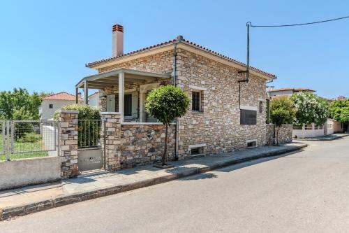 a brick house on the side of a street at Chroma Pelion Villas in Kato Gatzea