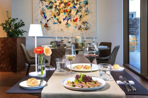 a table with plates of food and glasses of wine at Hotel Lago Maggiore - Welcome! in Locarno