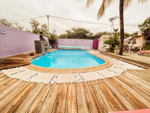 a swimming pool with a wooden deck and a wooden floor at 5 - LE VACOA - CHAMBRE 5 Rdc D in Saint-Paul