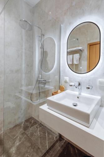 a white bathroom with a sink and a mirror at Old Ijevan Boutique Hotel in Ijevan