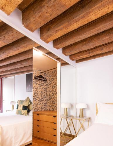 a bedroom with white walls and wooden ceilings at Palazzetto Pisani Grand Canal in Venice