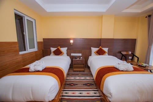 a hotel room with two beds and a window at Hotel Hidden Kingdom in Pokhara