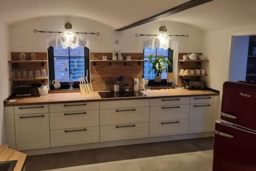 eine große Küche mit weißen Schränken und einem Waschbecken in der Unterkunft Cottbus Merzdorf Bauernhaus Ferienhaus in Cottbus