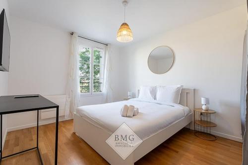 une chambre blanche avec un lit et un miroir dans l'établissement Bellagio appartement Disneyland, à Serris