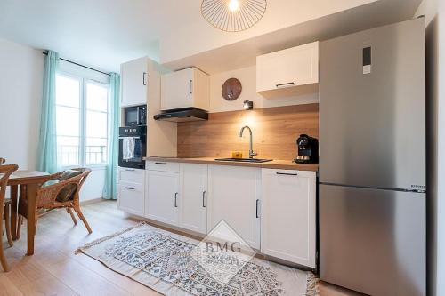 une cuisine avec un réfrigérateur en acier inoxydable et une table dans l'établissement Bellagio appartement Disneyland, à Serris