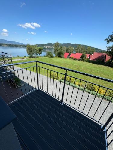 a balcony with a view of a river and a field at Noclegi Laguna in Żywiec