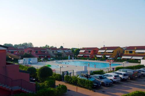 a large swimming pool with cars parked in a parking lot at RESORT VILLAGE AQUA MARINA FAMILY - Daily Rooms Tidying - CocktailsBar- Pet Friendly - with Hypermarket - Delivery Restaurant-Pizzeria - Room Breakfast with supplement - Ultra Fast Wi-Fi - Play Area for children - Olympic Swimming Pool - Parking in Caorle