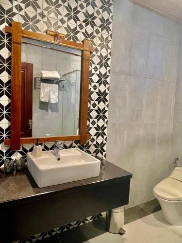 a bathroom with a sink and a toilet at Maison Duyên in Hue