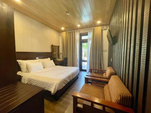 a hotel room with a bed and a couch at Maison Duyên in Hue