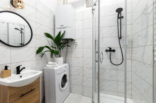 a bathroom with a shower and a washing machine at Wonderful Apartments in the Center of Krakow in Kraków
