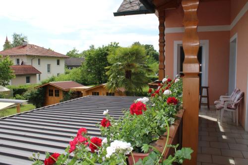 a balcony with red flowers on a house at Ferienwohnung und Gästezimmer Gaspar in Halbenrain