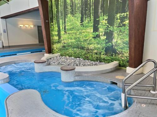 a pool in the middle of a room with a forest at BearHug AC, Pool, Hot Tub, Tennis, Close to Resort in Killington