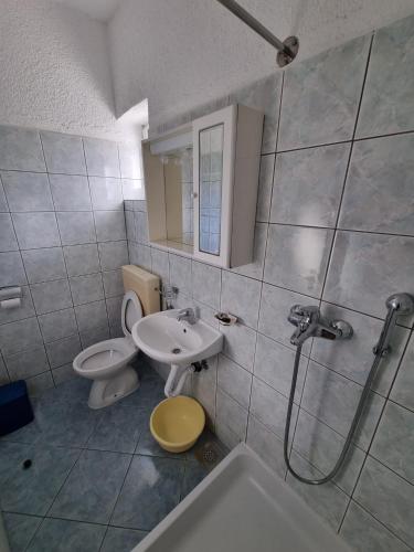 a bathroom with a toilet and a sink and a shower at Apartmani Bada in Pakoštane