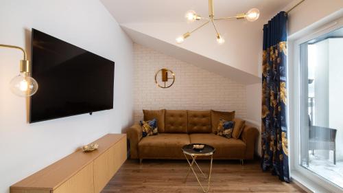 a living room with a couch and a flat screen tv at Spokojna, Sun & Snow in Wisła