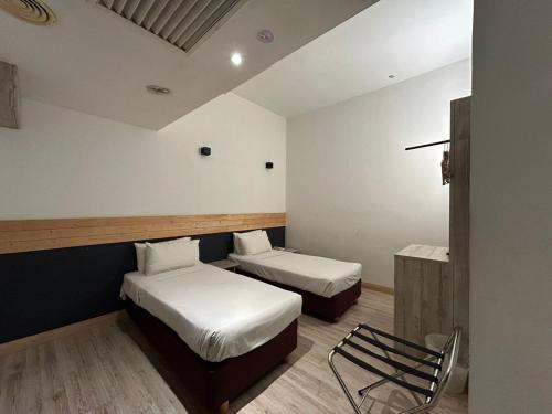 a room with two beds and a chair in it at Alamis City Kuala Lumpur - Formerly EDC Hotel Kuala Lumpur in Kuala Lumpur