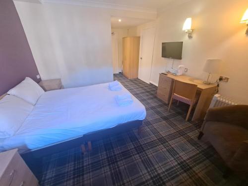 a hotel room with a bed and a desk at Britannia Edinburgh Hotel in Edinburgh