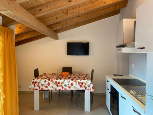 a kitchen with a table with chairs and a tv at Casa Gaia, La Casa Sui Tetti in Isolabona