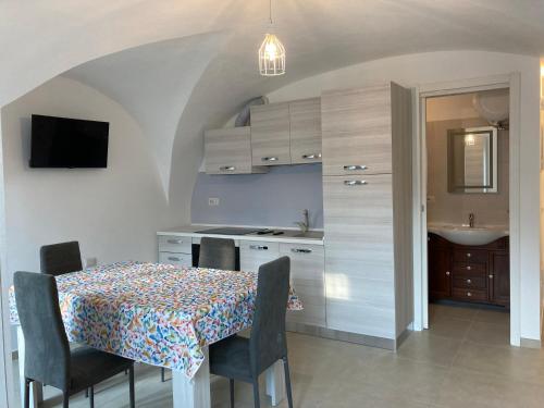 a kitchen with a table and chairs and a kitchen with a sink at Casa Gaia, La Casa Sui Tetti in Isolabona