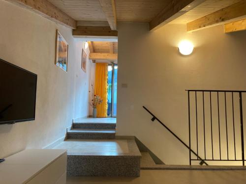 a living room with stairs and a television and a staircase at Casa Gaia, La Casa Sui Tetti in Isolabona