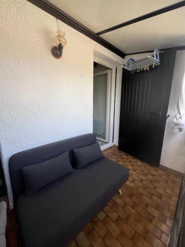 - un canapé dans une pièce avec un mur dans l'établissement Studio Aigues Mortes avec parking gratuit, à Aigues-Mortes