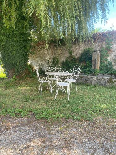 a table and chairs sitting in the grass at Appartements de la ferme du Brocey in Crolles