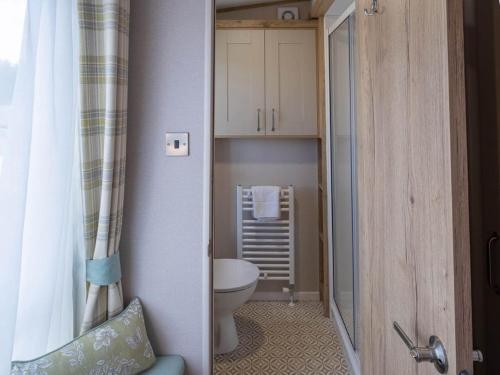 a small bathroom with a toilet and a sink at Pinewoods Beach Luxe no.4 – dog friendly in Wells next the Sea