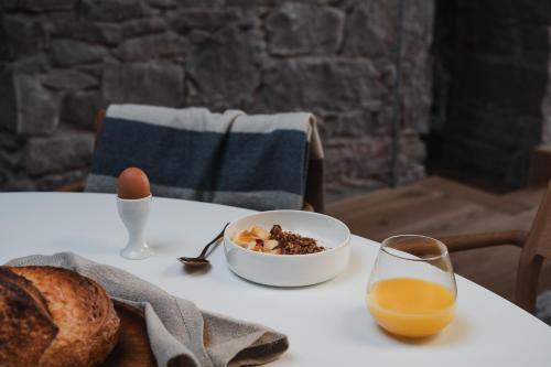 a table with a bowl of cereal and a glass of orange juice at The Church Tower in Crieff