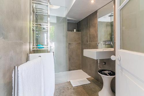 Un baño con lavabo, inodoro y espejo. en Portas do Castelo Apartments, en Lisboa