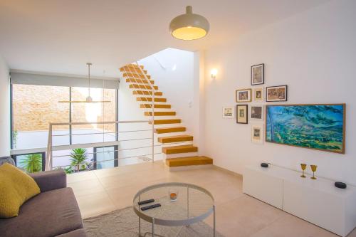a living room with a staircase and a glass table at Townhouse Bombarda in Lagos