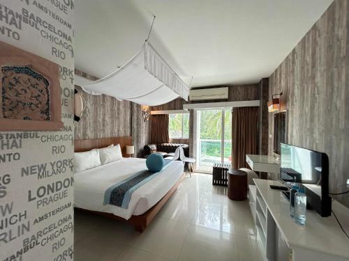 a bedroom with a bed and a television in it at Benyada Lodge - Surin Beach in Surin Beach
