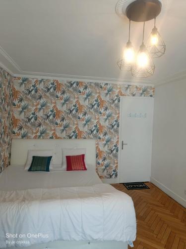- une chambre avec un lit blanc et un papier peint floral dans l'établissement Grande chambre d'hôte Lit king size - 3 mins Gare Annemasse - Genève accès direct, à Annemasse