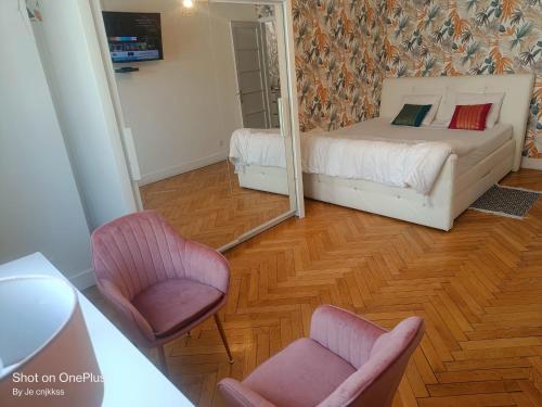 アンヌマスにあるGrande chambre d'hôte Lit king size - 3 mins Gare Annemasse - Genève accès directのベッドルーム1室(ベッド1台、椅子2脚、鏡付)