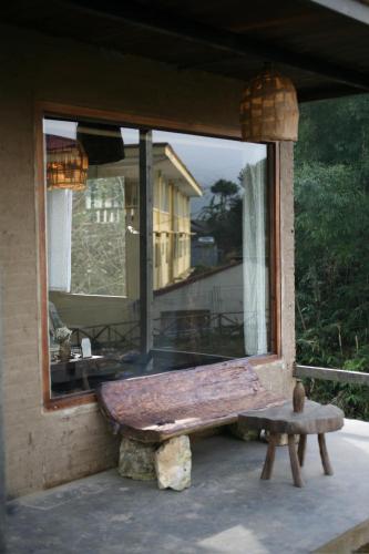 a wooden bench sitting in front of a window at Sa Moc - La Maison House & Bungalow in Sa Pa