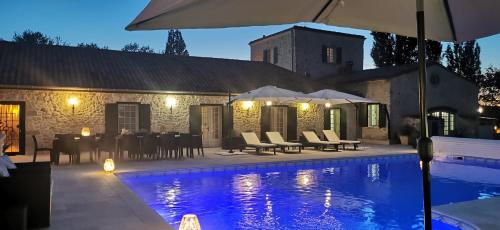 une villa avec une piscine la nuit dans l'établissement Chambres d'Hôtes Domaine de Beunes, à Pailloles