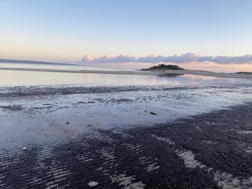 a beach with a small island in the water at Baudin Beach Holiday Units in Baudin Beach