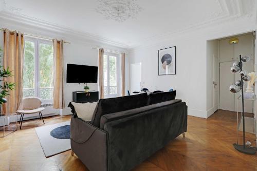 un salon avec un canapé et une télévision dans l'établissement Magnificent apartment - 1BR-4P - Parc Monceau, à Paris