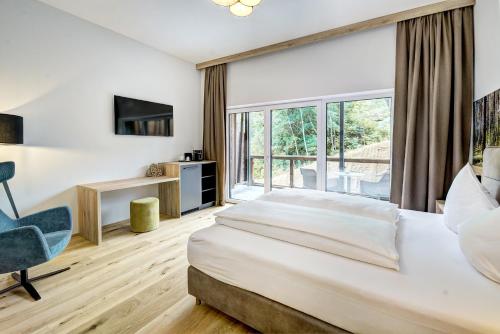 a hotel room with a bed and a large window at Das Förstereck in Viehhofen