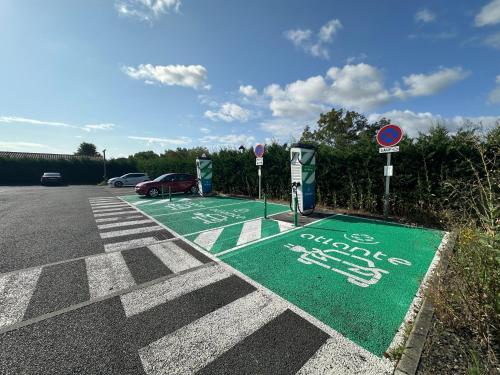 a parking lot with a green handicapped sign on it at Hôtel Gardenia Bordeaux Est in Yvrac