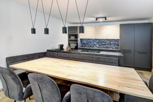 a kitchen and dining room with a wooden table and chairs at Das Förstereck in Viehhofen